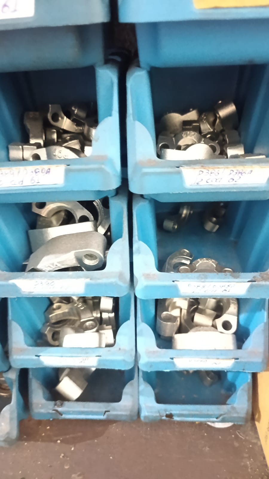 Meios flanges hidráulicos em caixas organizadoras azuis etiquetadas